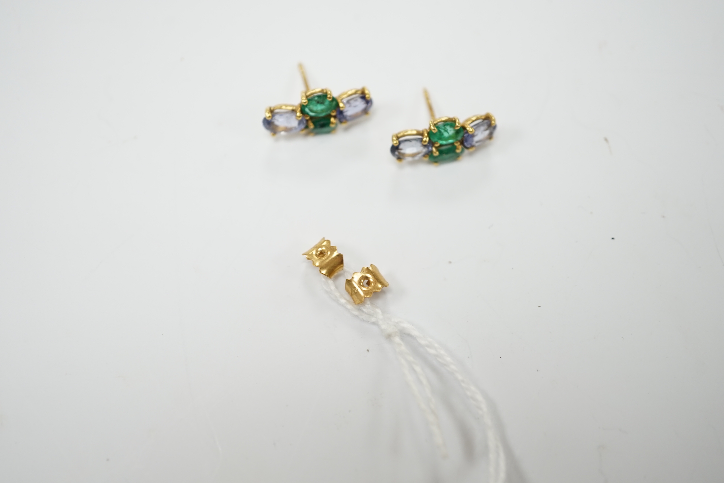 A modern pair of 18ct gold, two stone emerald and two stone sapphire set ear studs, 15mm by 7mm, gross weight 3 grams.